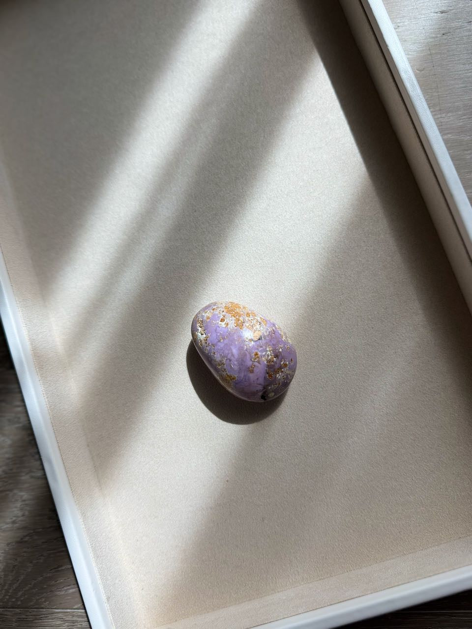 The phosphosiderite stone lit from the side, showing its lavender surface