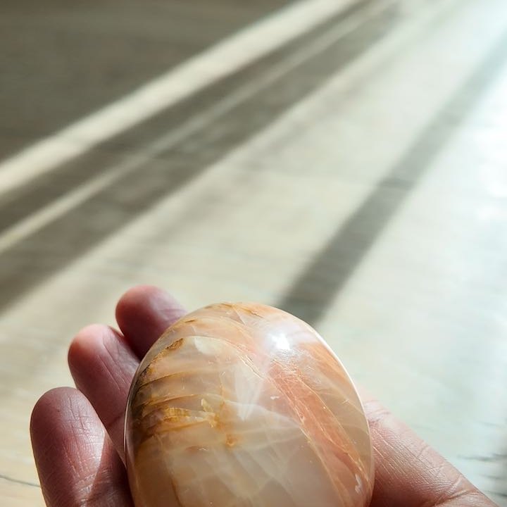 KINDLING peach moonstone held in hand