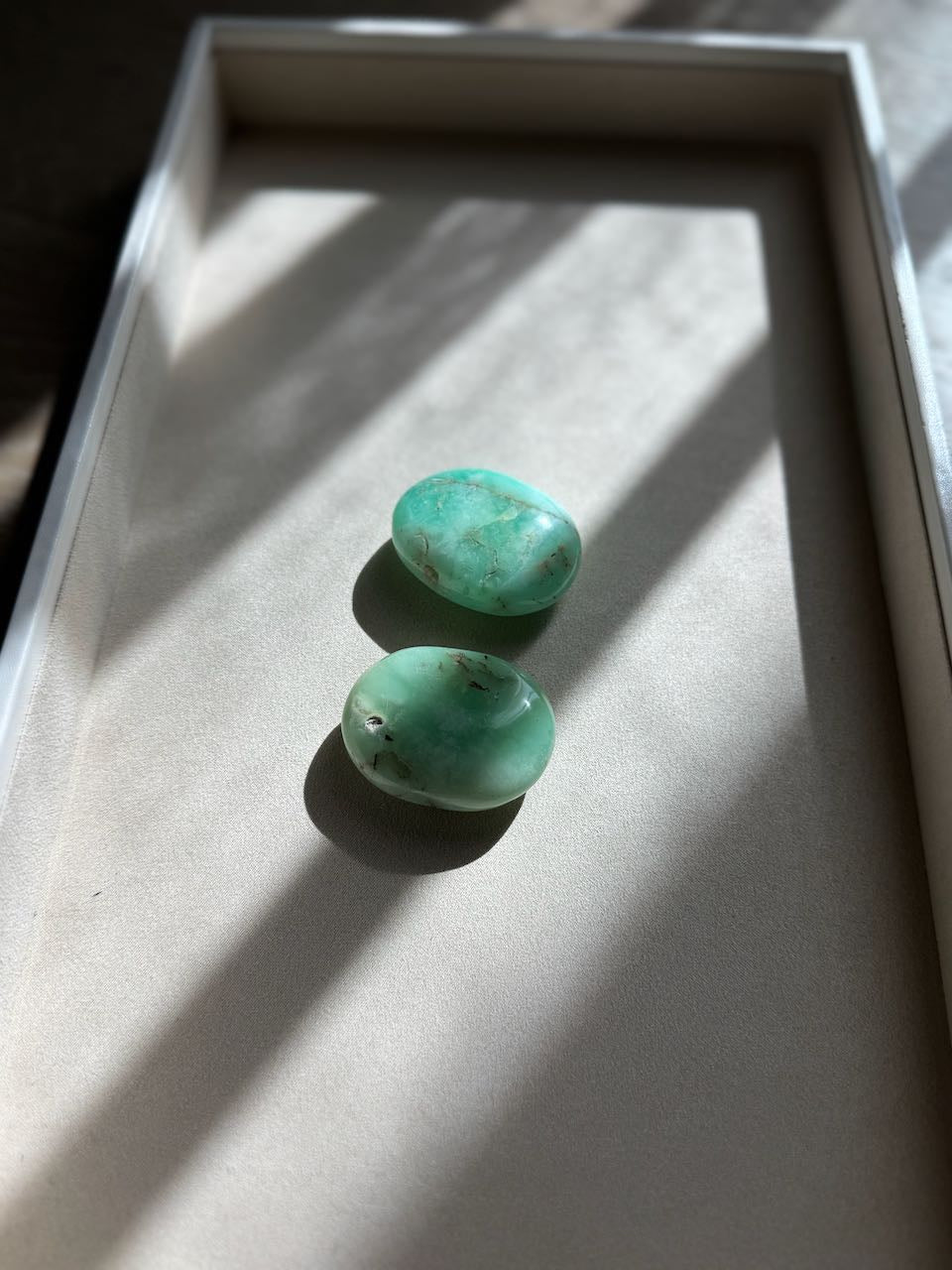 Chrysoprase palm stones seen from the side, showing their rounded palm shape