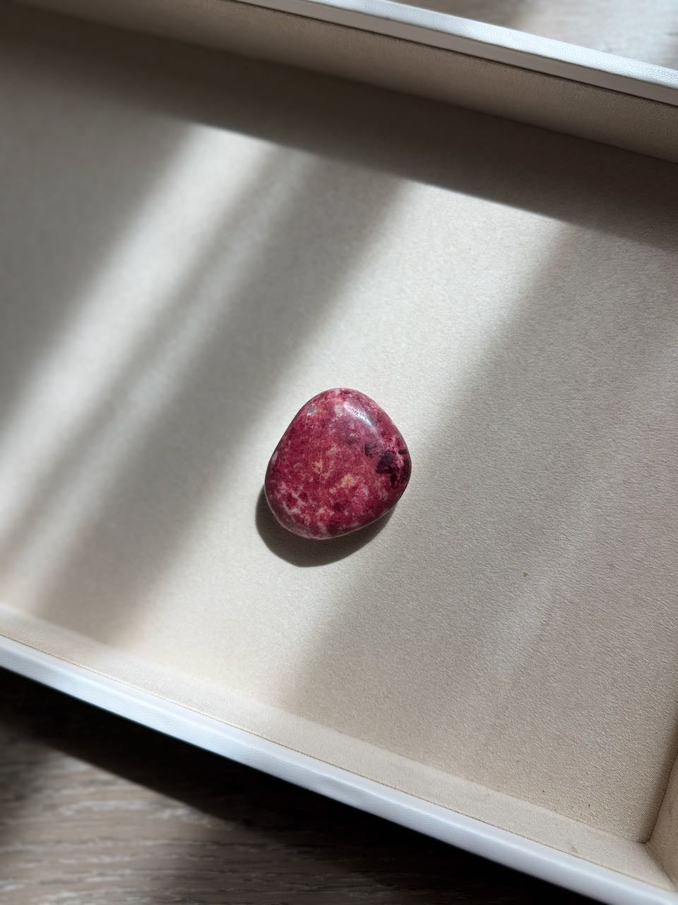 Thulite palm stone in rose and cream, seen from above